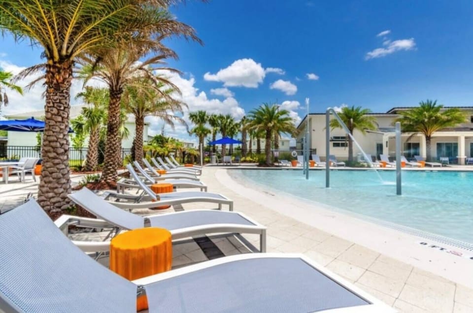 Bask in the sun by the shimmering pool, where sleek lounge chairs invite you to unwind. Palm trees sway gently in the breeze, enhancing the vibrant atmosphere and making it the ideal spot to relax with a refreshing drink.