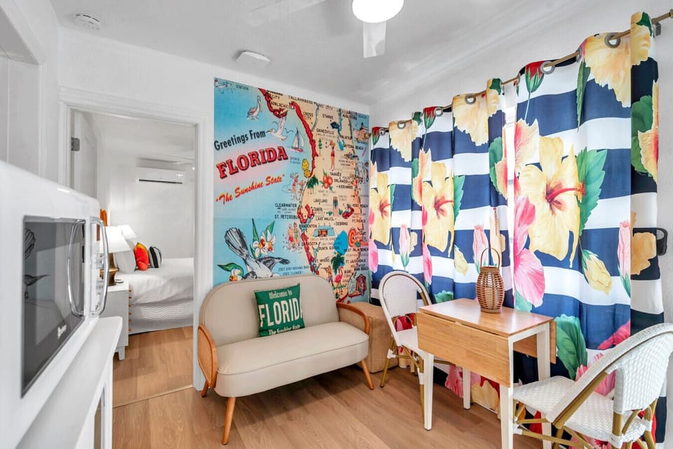 Colorful living area w/ bold art, cozy seating, & playful accents that set a cheerful tone.