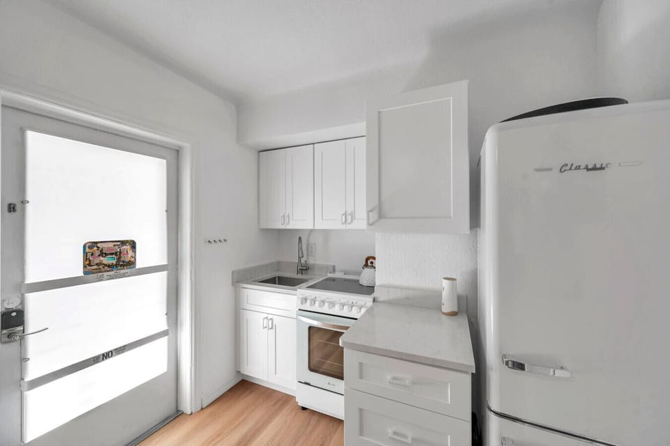 Compact kitchen corner w/ bright cabinetry & a tidy setup that keeps everything within reach.