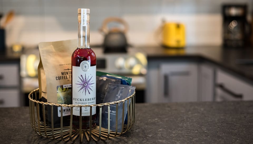 Guest welcome basket including a local spirit, coffee, and tea