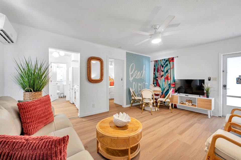 Open-concept living space w/ warm tones, woven textures, & a relaxed beachy feel throughout.