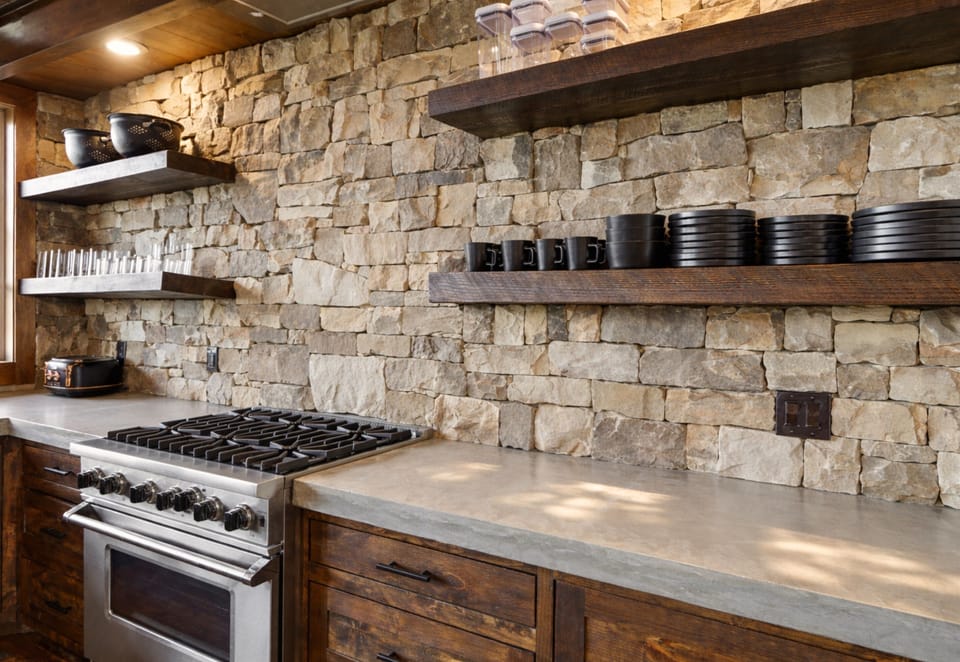 Thoughtful stone accents and open shelving add charm and functionality to this beautifully designed kitchen.