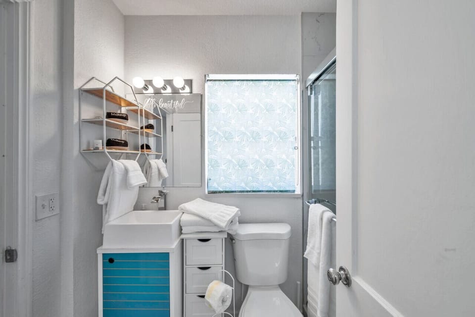 Light-filled bathroom vanity w/ mirror, shelving, and a fresh, airy feel