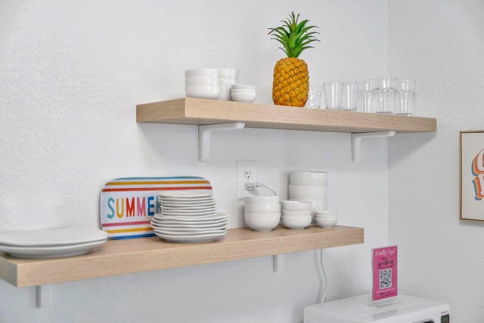 Open shelves styled w/ dishware & decor, adding charm & function to the kitchen.
