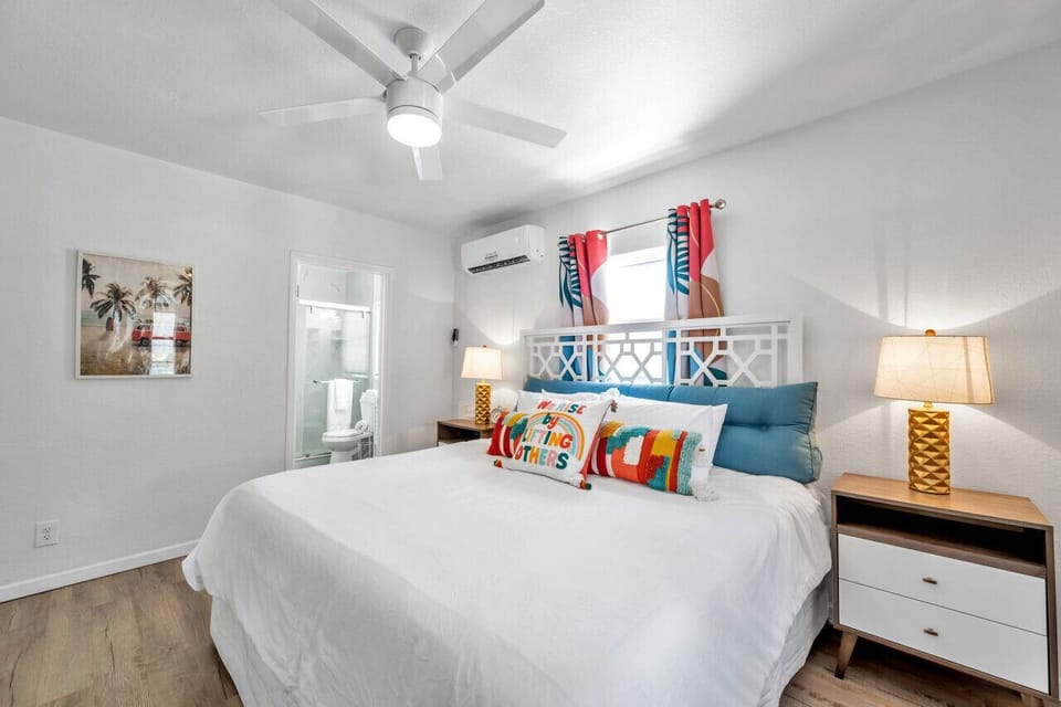 Calm bedroom w/ crisp bedding, soft lighting, & a peaceful atmosphere.