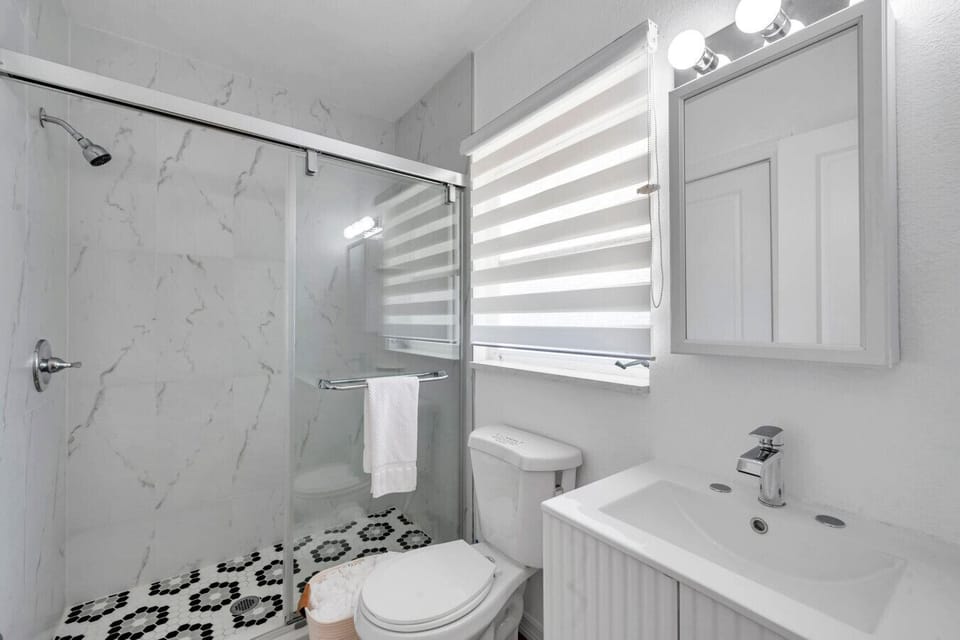 Fresh bathroom w/ a sleek shower, modern vanity & bright, clean finishes.