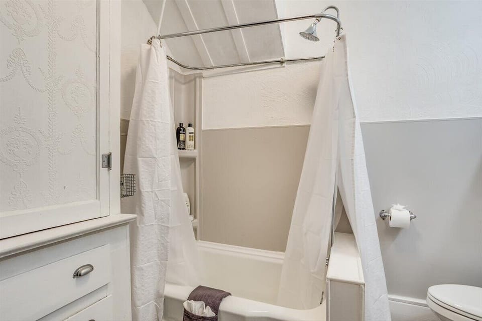 Bright, tidy bathroom with tub-shower combo and built-in storage