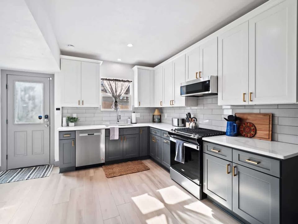 - Spacious kitchen with white and gray cabinetry design   - Stainless steel appliances with subway tile backsplash   - Modern layout ideal for cooking and entertaining  