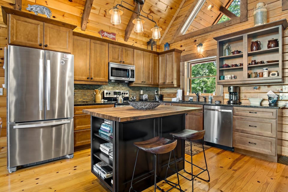 Sleek kitchen with island seating for 2, a dishwasher & a standard Drip-style coffeemaker.