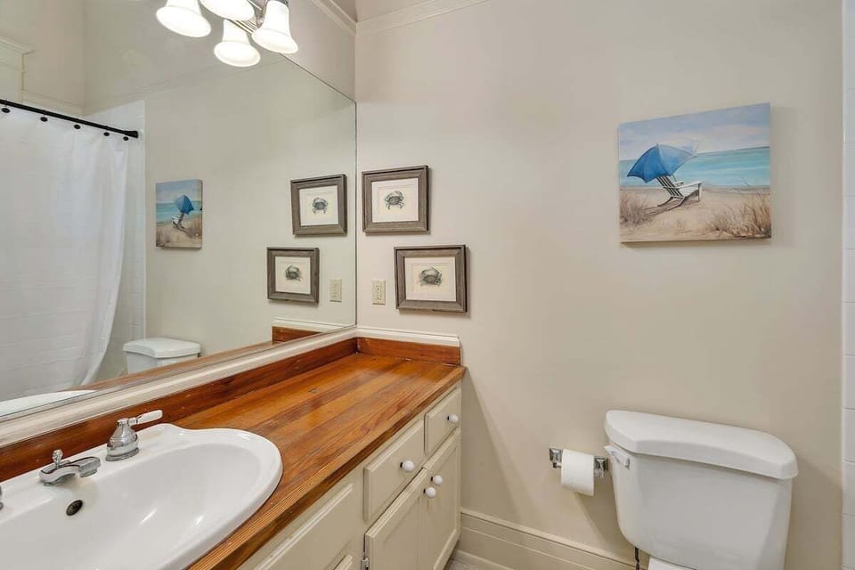 Guest bathroom with wooden counterspace and large mirror