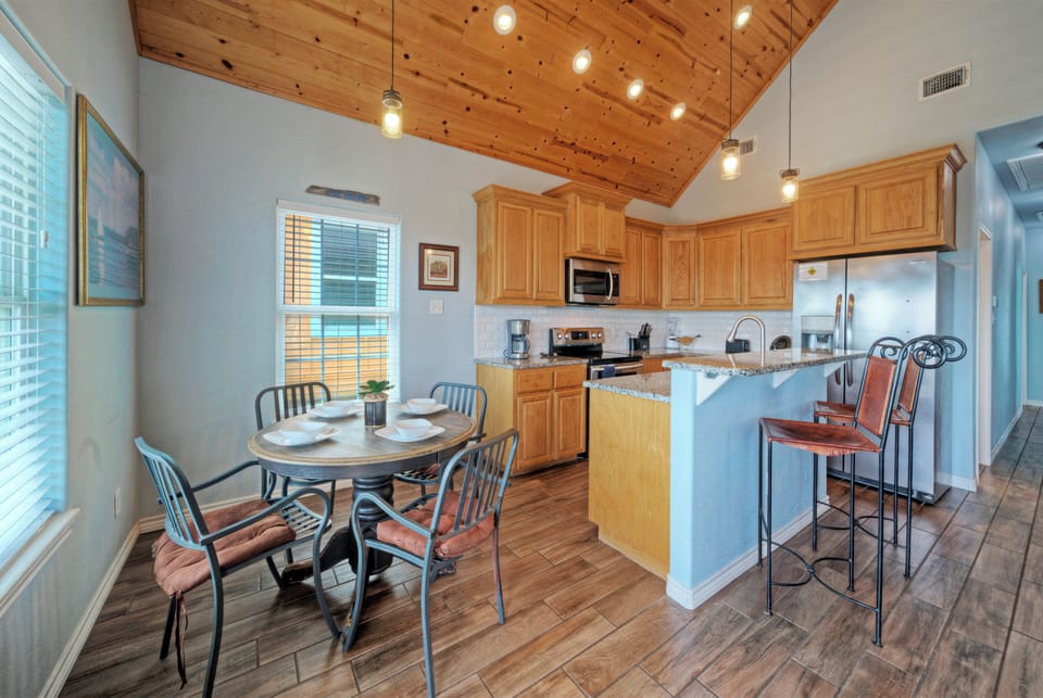 Open kitchen and dining area with vaulted wood ceilings and easy flow into the living room.