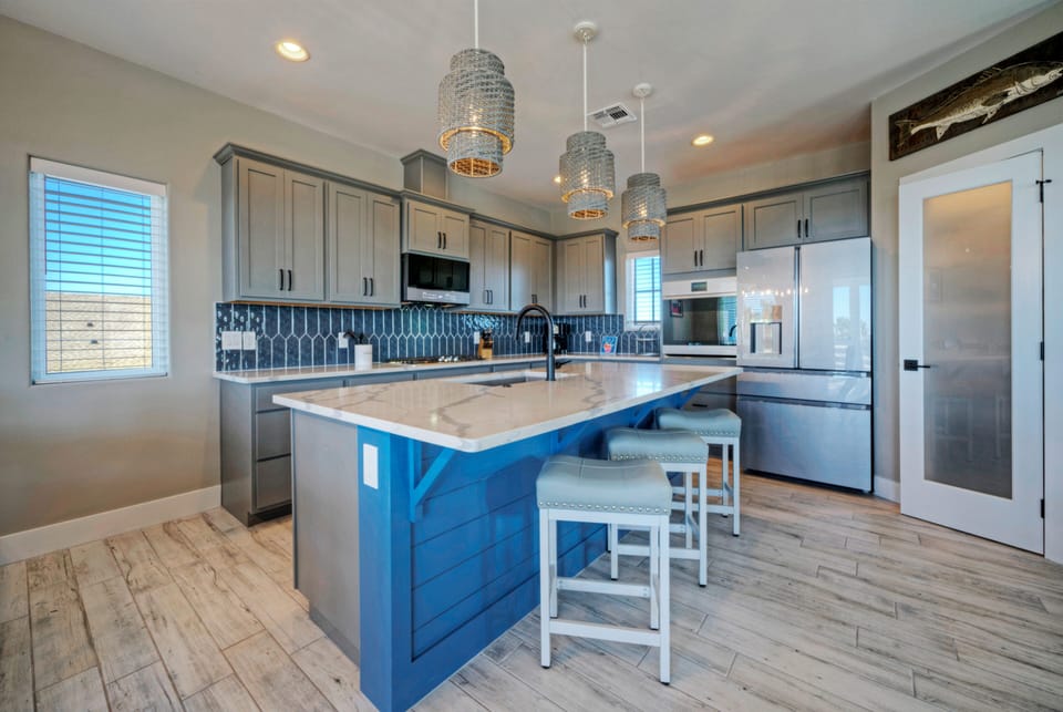 Modern kitchen features an island with barstool seating.