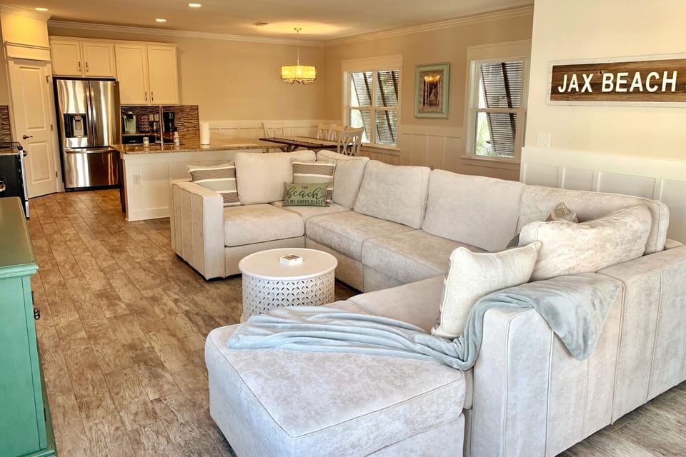 Large gathering area with oversized couch and 75" TV.