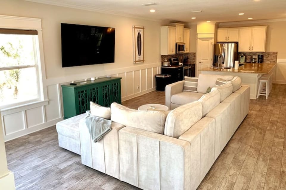 Large gathering area with oversized couch and 75" TV.