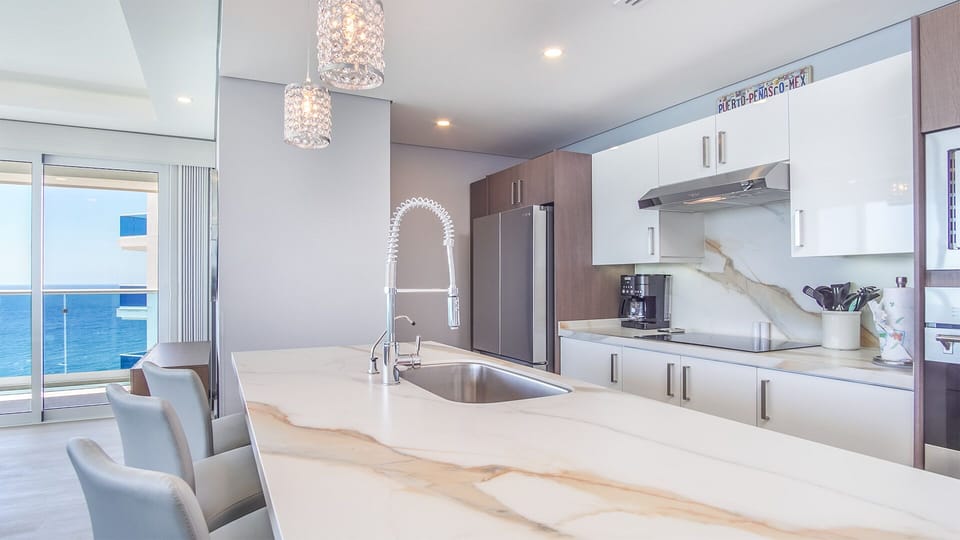 Large kitchen area defined by a long kitchen island.