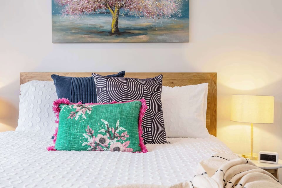 MASTER BEDROOM: Soft blue tones and airy white accents, this calm coastal bungalow-inspired room features a queen bed and AC for year-round comfort.