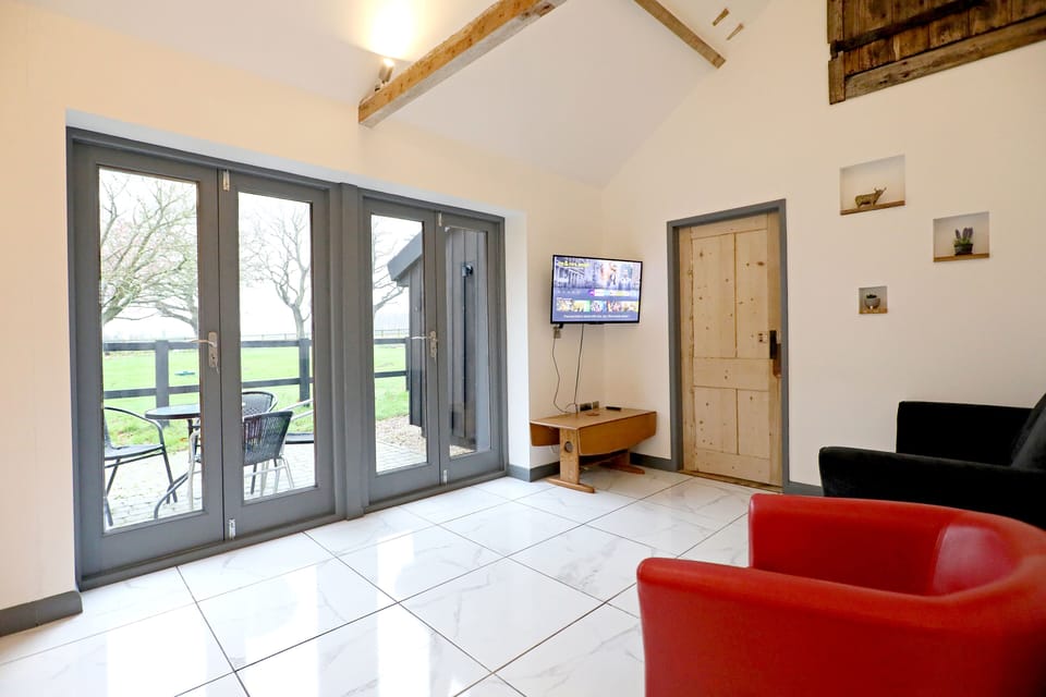 Relax in style with our comfortable single couches in the living room, strategically positioned to offer the perfect view of the outside through wide glass doors. Enjoy your favorite shows on the TV while soaking in the breathtaking scenery. The ultimate blend of comfort and serenity awaits!