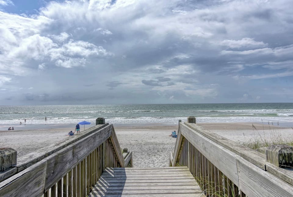Head down the boardwalk steps and you're on sand in minutes — no long walk, no shuttle, just flip-flops and the short trip everyone else is jealous of.