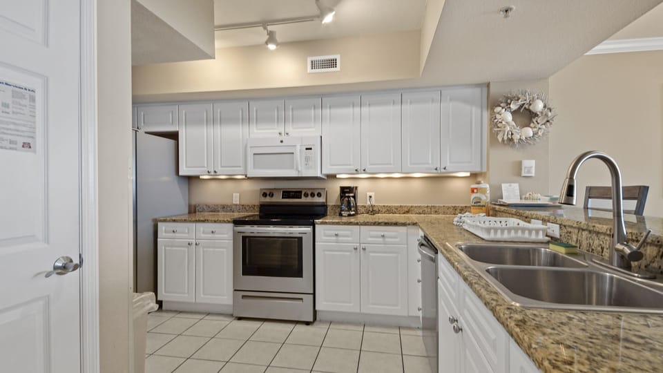 The fully equipped kitchen features granite countertops and stainless-steel appliances.
