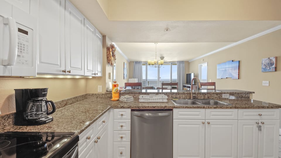 The fully equipped kitchen features granite countertops and stainless-steel appliances.