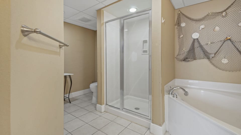 The spacious master bathroom features his and hers sinks, large soaking tub, and walk-in shower.