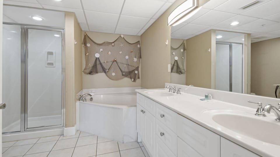 The spacious master bathroom features his and hers sinks, large soaking tub, and walk-in shower.