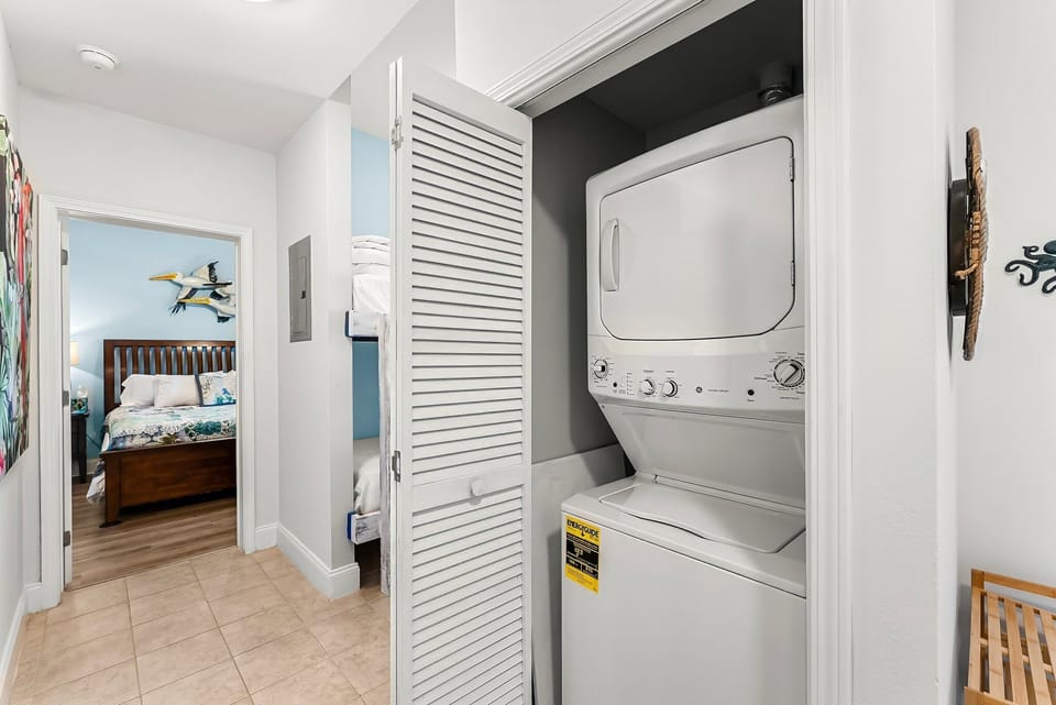 Stacked washer and dryer conveniently located near the bedroom.
