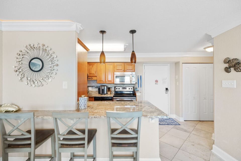 Coastal kitchen with granite counters and bar seating, perfect for quick breakfasts and easy dinners after the beach.