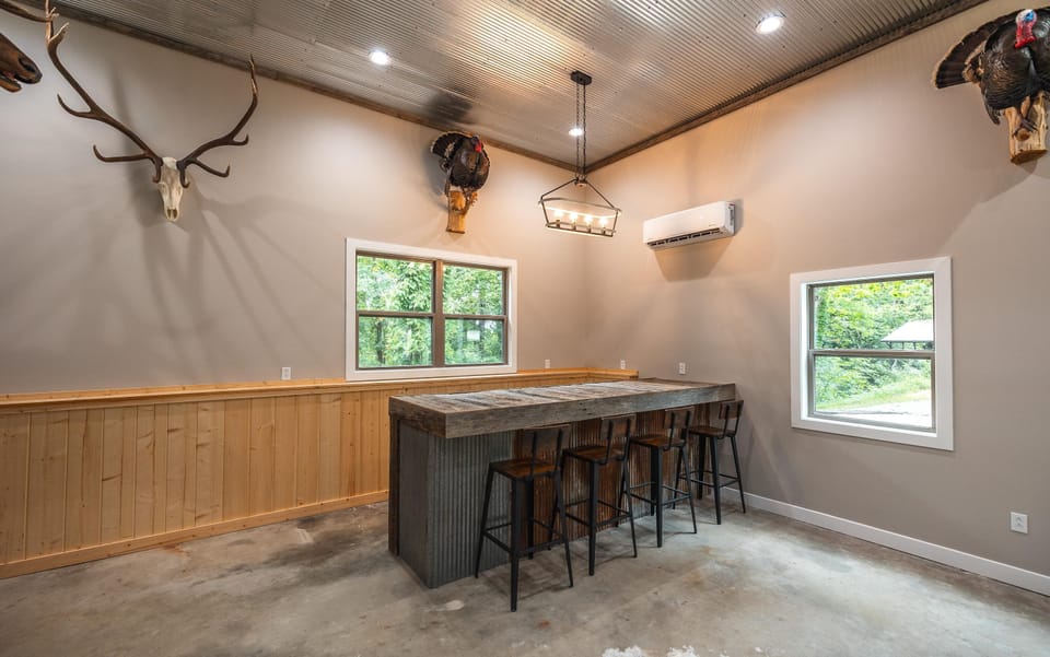 View of Bar and seating for 4.  Backside of bar is open for storage.  The bar top is out of barnwood we took off an old barn on our farm along with the tin.  This room has a separate ac/heat unit for it's own climate control.