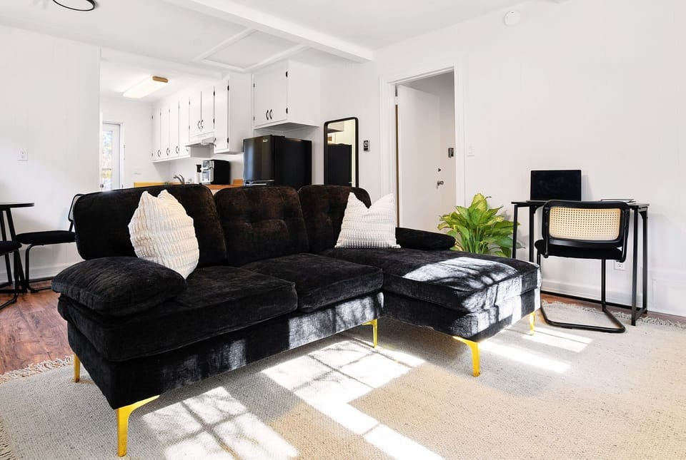 Comfortable couch with a chez lounge and desk for remote work.