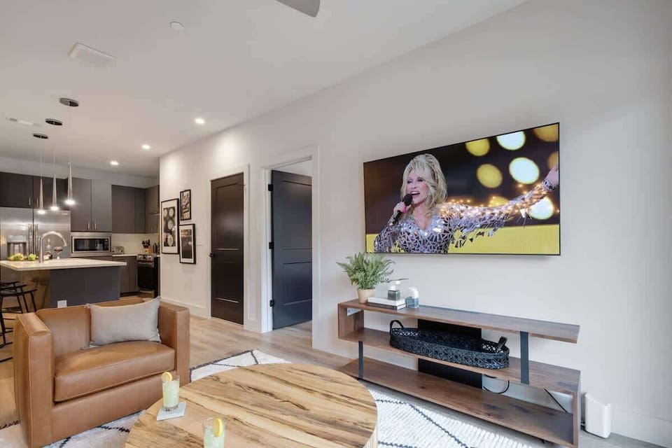 1st Unit: Bright living room with comfortable seating, smart TV, designer decor, and access to the private patio.