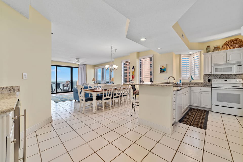 Dine in style with ample space for everyone. This inviting dining area features a charming table for family meals, complemented by additional seating at the convenient breakfast bar.