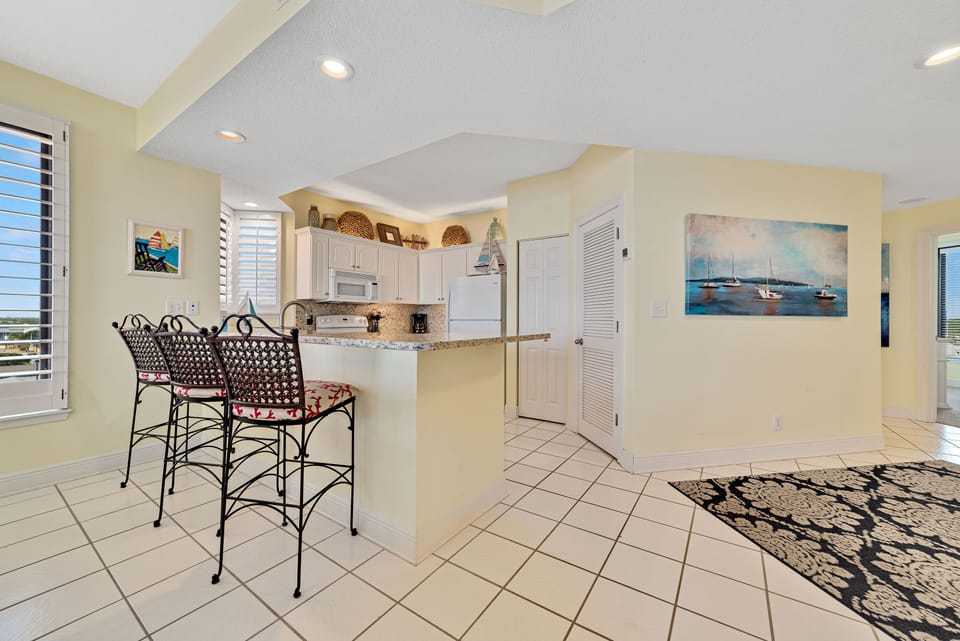 This beautifully designed kitchen boasts a spacious island with a contrasting stone countertop and stylish stools, creating a natural hub within the home.