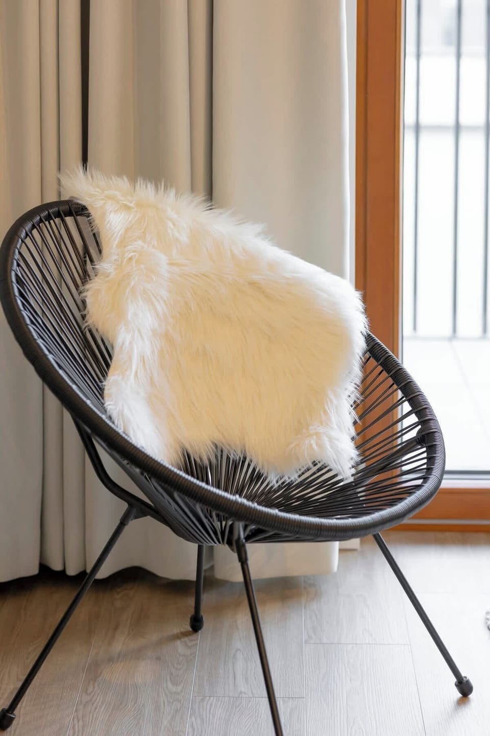 A black round chair with a faux fur throw, adding a touch of luxury and comfort to the room.


