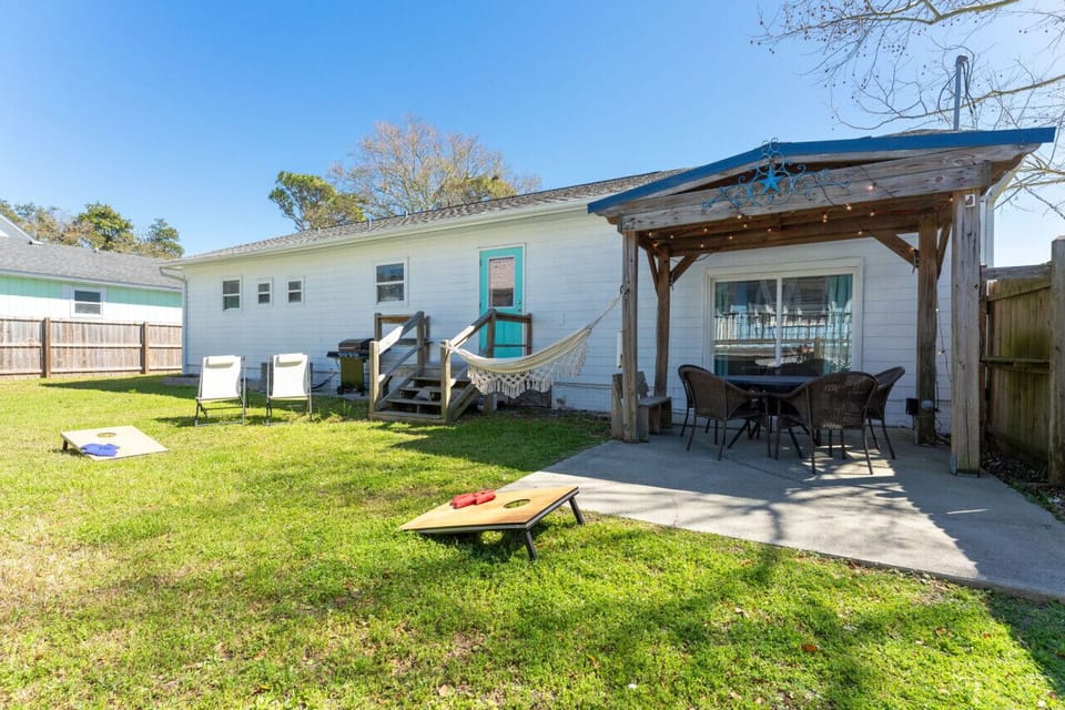 Fenced-in backyard with games, grill, dining areas, and more.