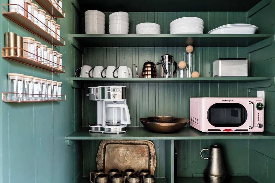 Adorable pantry stocked with coffee maker, microwave, toaster and one-of-a-kind mounted spice rack