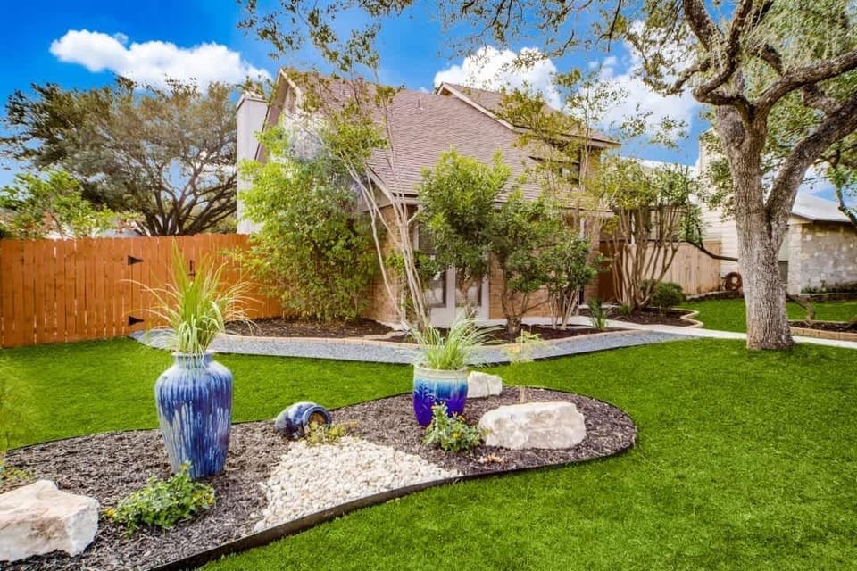 This charming front yard features vibrant landscaping, unique planters, and a warm inviting entrance that sets the tone for a relaxing getaway