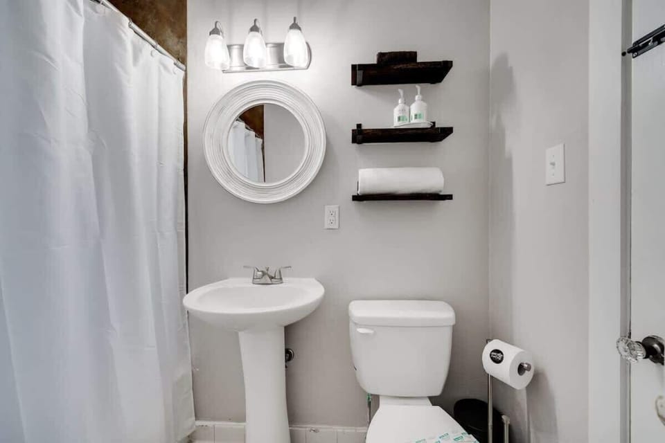Fresh and modern bathroom with a walk-in shower, pedestal sink, and simple, clean design.