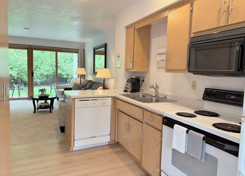 A full kitchen fully stocked with dishware, glassware, and cookware.