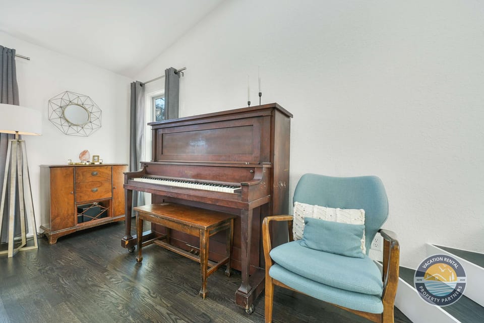 Charming piano corner adds character to the space. A fun touch for music lovers or a quiet spot to relax with a book.