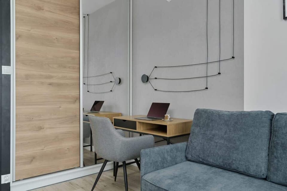 A comfortable seating area with a blue sofa, a wooden coffee table, and decorative wall hangings, blending contemporary and rustic elements.


