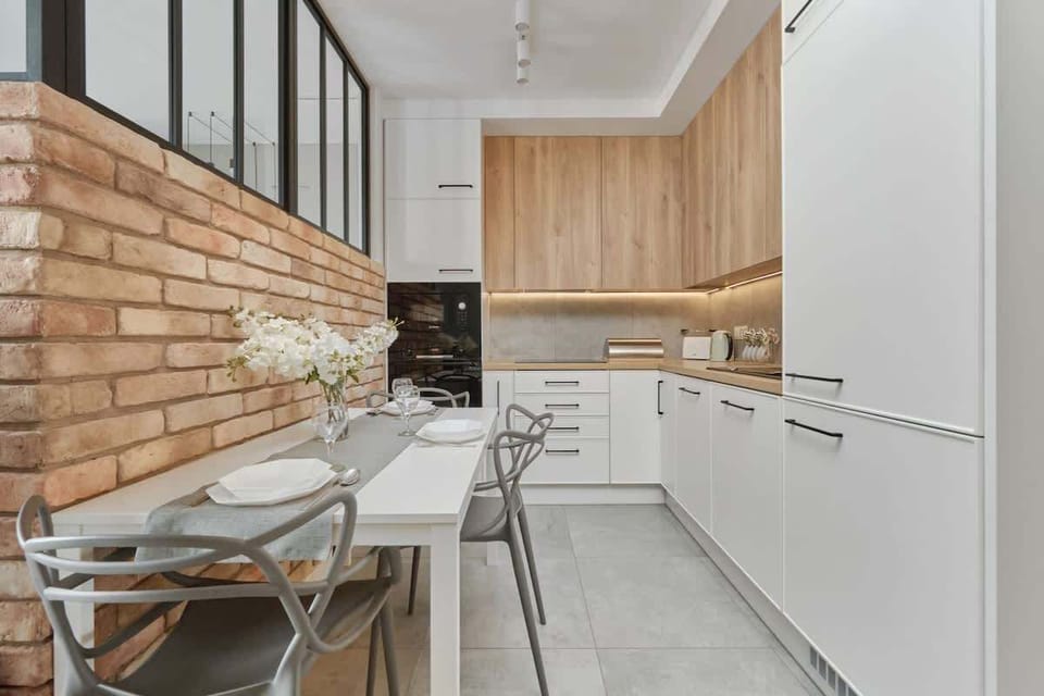 Another view of the kitchen and dining area, highlighting the modern industrial aesthetic with a mix of wood, metal, and brick finishes.

