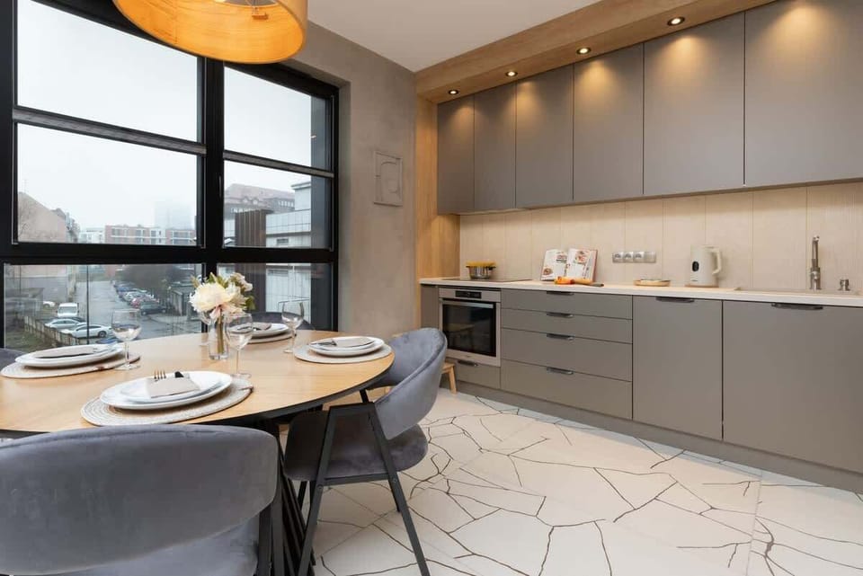 Another perspective of the dining area, emphasizing the open-plan layout, modern cabinetry, and warm lighting that complements the sleek decor.

