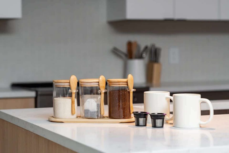 Coffee, sugar, tea, with reusable k cups, and mugs in the office