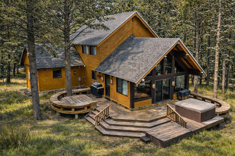 Step out onto the spacious back deck surrounded by tall pines and peaceful mountain grasses. Grill dinner, relax on the curved seating deck, or soak in the private hot tub after a day exploring Yellowstone and Island Park. 🌲