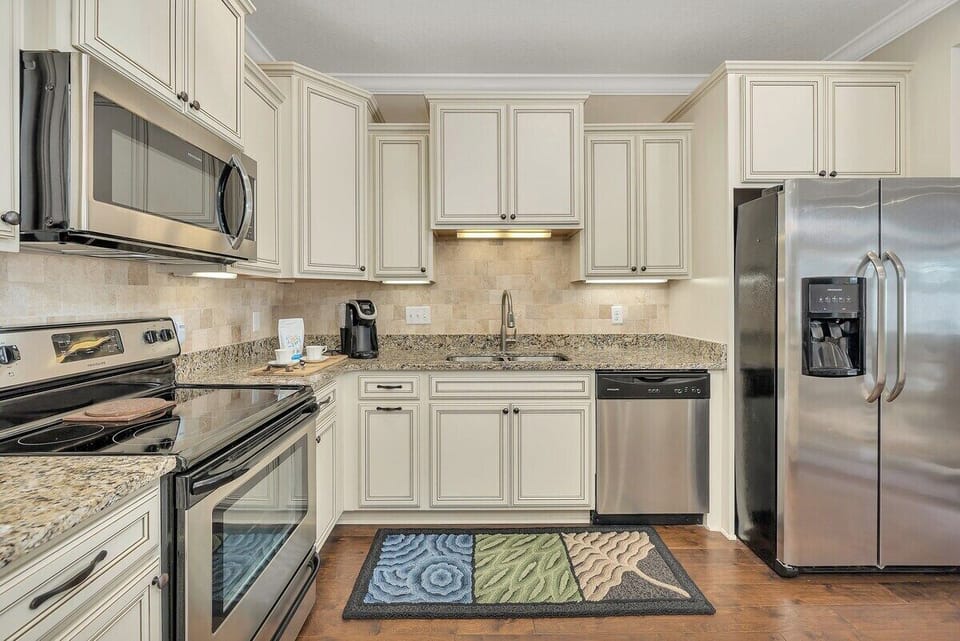 White kitchen with granite counters and stainless appliances
