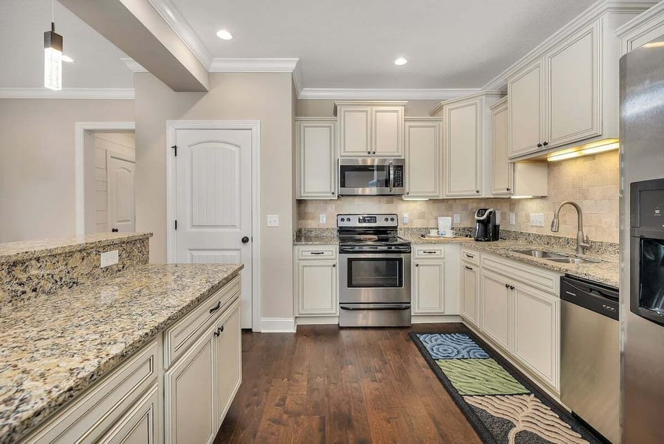 White kitchen with granite counters and stainless range
