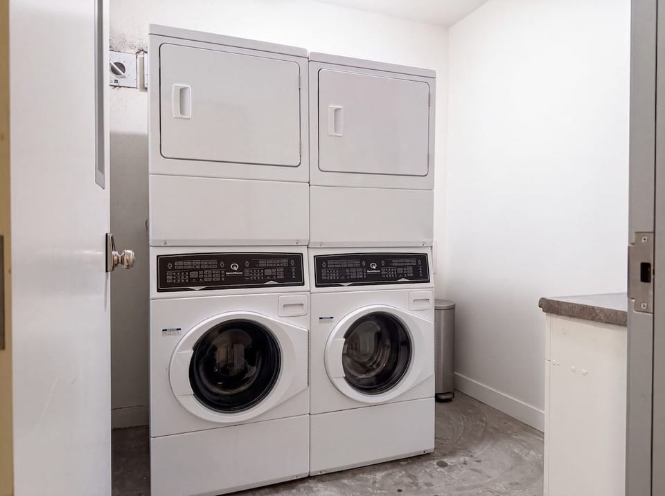 Shared laundry room in the building with two washer and dryer sets.
