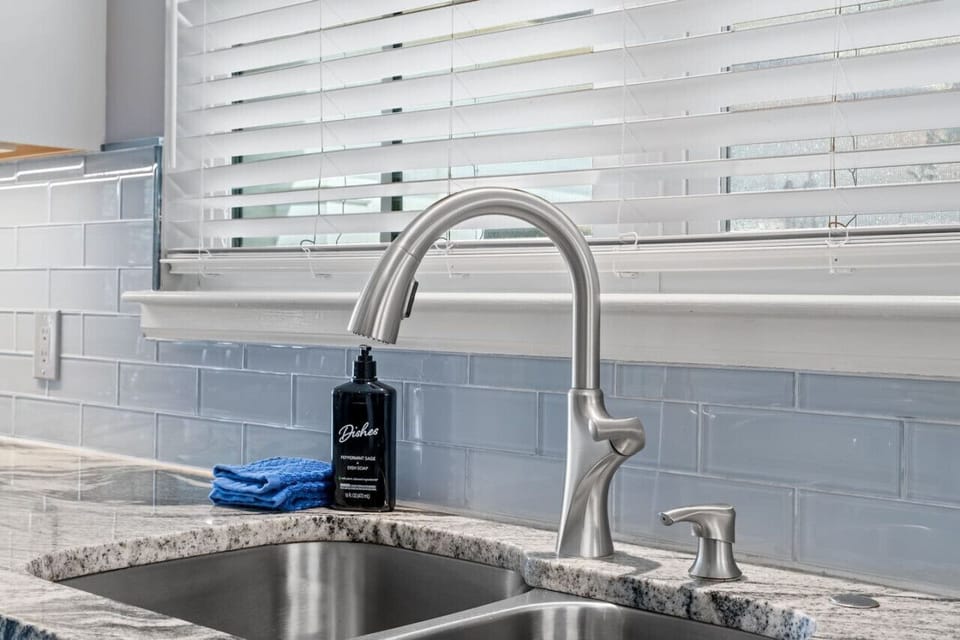 Immerse yourself in luxury and convenience in our modern kitchen, where the sink area is complemented by sleek stainless steel appliances.