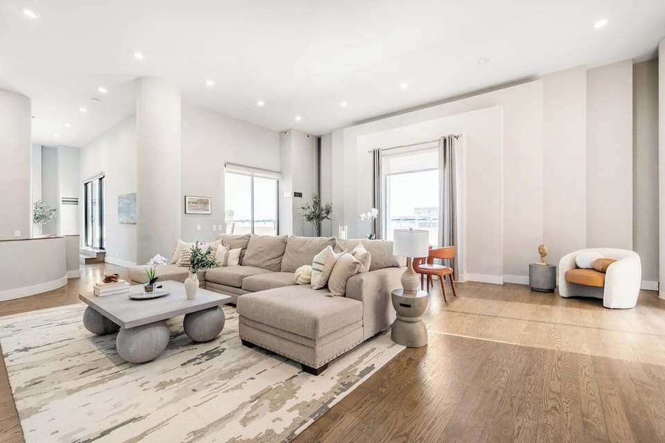 Living room drenched in natural light. Dining area in the back.